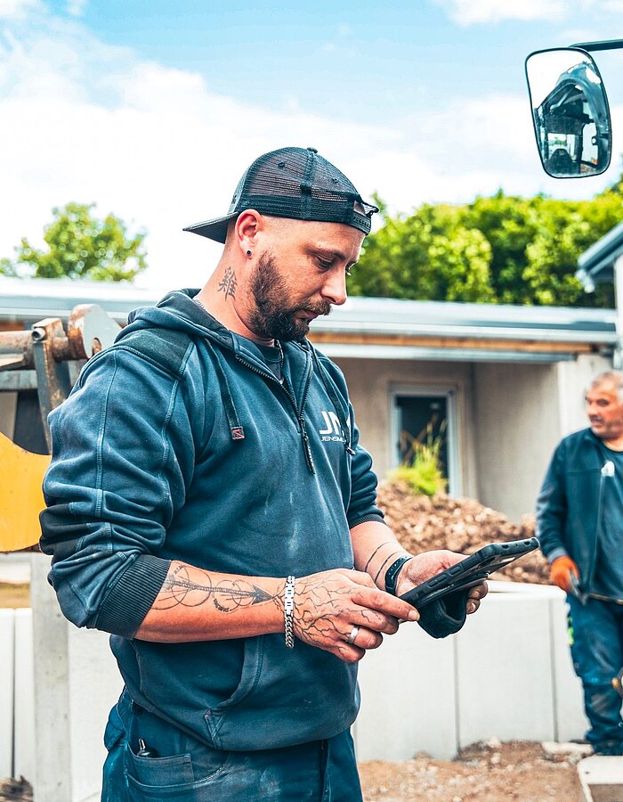 Mitarbeiter eines Bauunternehmens arbeitet mit einem Tablet auf der Baustelle