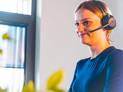 Dataflor Mitarbeiterin mit Headset am Arbeitsplatz