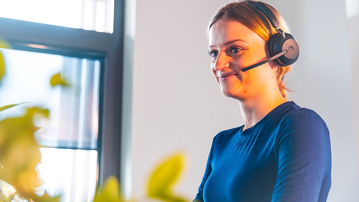 Dataflor Mitarbeiterin mit Headset am Arbeitsplatz